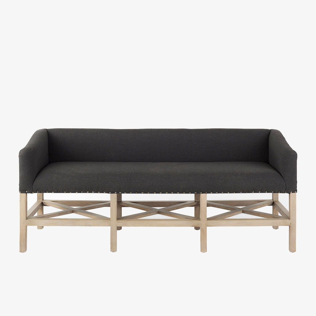 Grey upholstered accent bench with trellis wood base and small bolster back and nail head finish