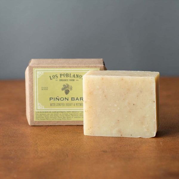 Los Poblanos brand piñon bar soap in package on a wood counter