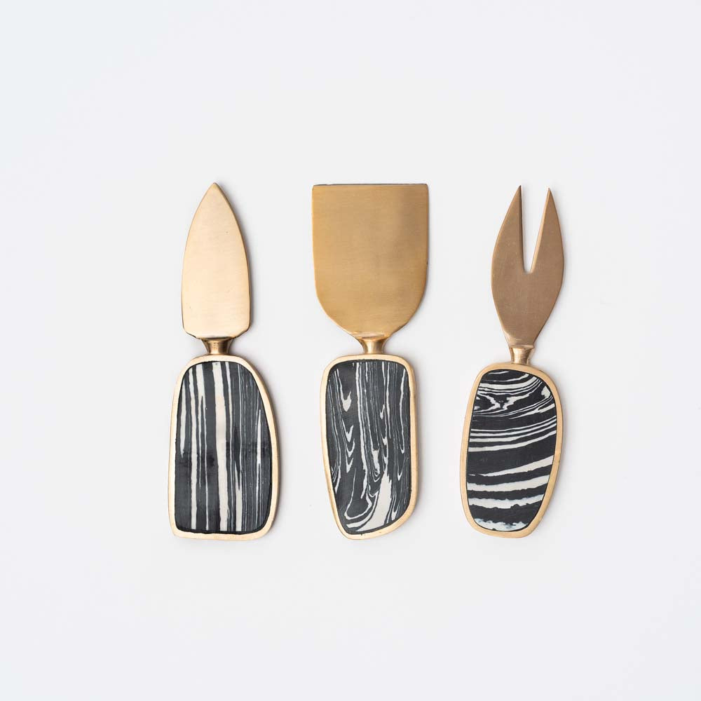 Brass and black stone set of three cheese servers on a white background