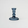 Blue pressed glass candlestick on a white background