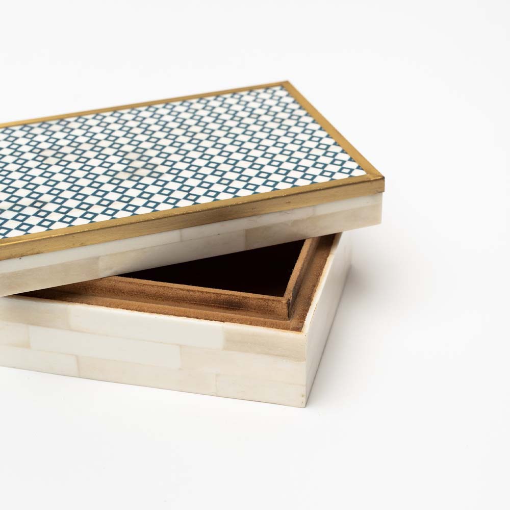 Close up of Decorative box with blue and white geometric bone inlay top with brass trim