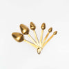 Brass finish measuring spoons on a white background