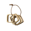 Set of four square brass finish metal napkin rings on a white background