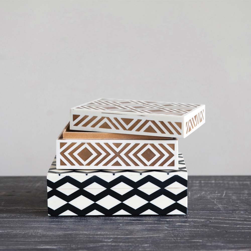 Two boxes with inlay of brown and white and black and white stacked on top of each other 