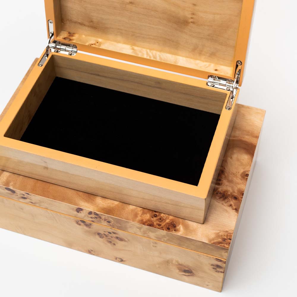 Two burl wood boxes with the top box lid open revealing black felt interior on a white background