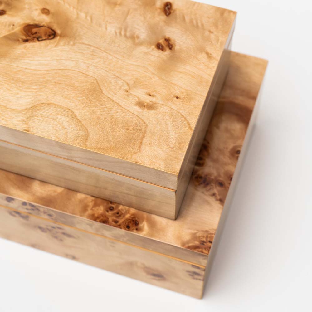 Close up of two burl wood boxes stacked on top of each other on a white background