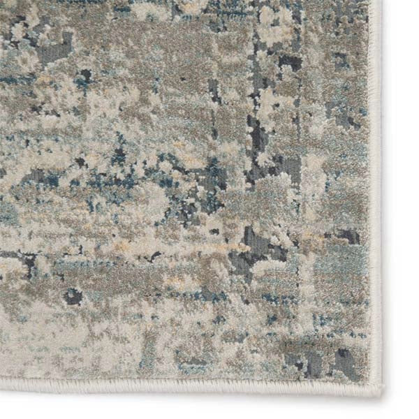Close up of Jaipur Living CAICOS rug with tones of blue, gray, ivory, and cream on a white background