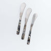 Three canape knives with resin handle on a white background