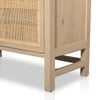 Close up of wood legs on Four hands furniture brand caprice book case with light wood and rattan