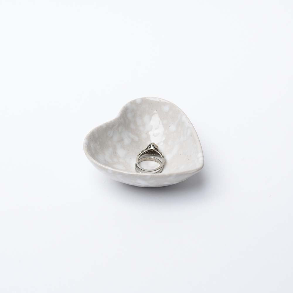 Decorative white stoneware heart dish on a white background