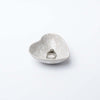 Decorative white stoneware heart dish on a white background