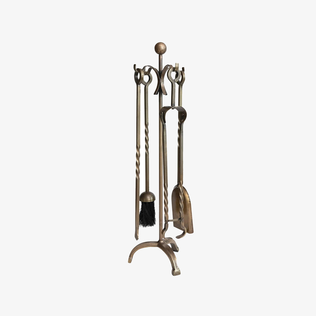 aged brass fire place tools made from cast iron on a white background