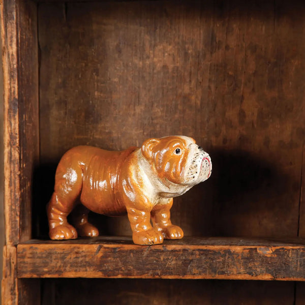 Cast iron orange and white bulldog on a wood shelf