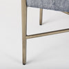 Close up of metal legs on Bench with metal frame and grey upholstered seat on a white background