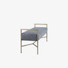 Side view of Bench with metal frame and grey upholstered seat on a white background