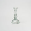 Clear pressed glass candlestick on a white background