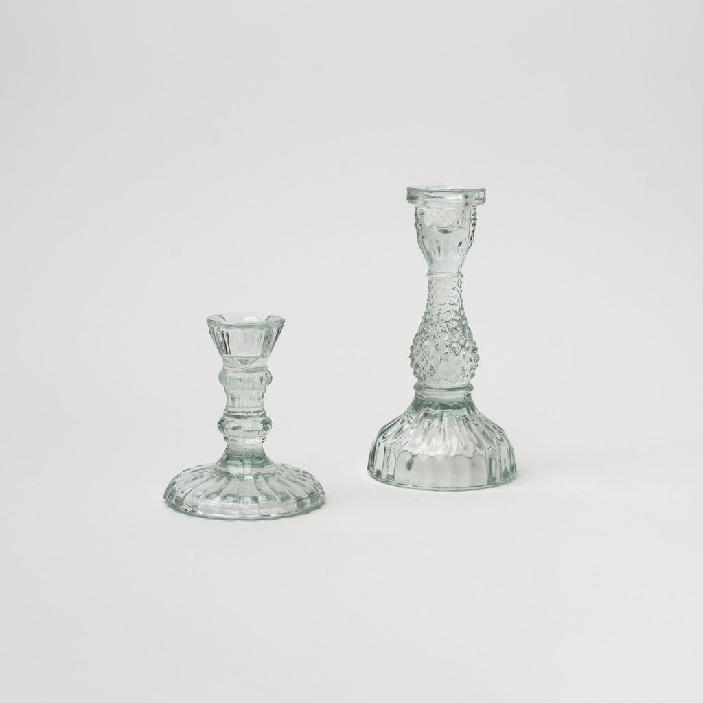 Pair of clear pressed glass candlesticks on a white background