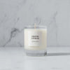 Makana brand coastal cypress glass candle on a marble counter