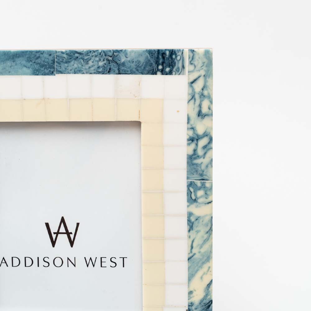 Close up of White and blue resin picture frame on a white background
