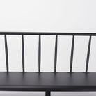 Close up of Black metal bench with Windsor chair styling and curves back rail on a white background