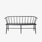 Black metal bench with Windsor chair styling and curves back rail on a white background