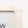 Close up of  Zodax brand white bone inlay picture frame on a white background