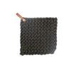 Charcoal grey crocheted pot holder with leather loop on a white background