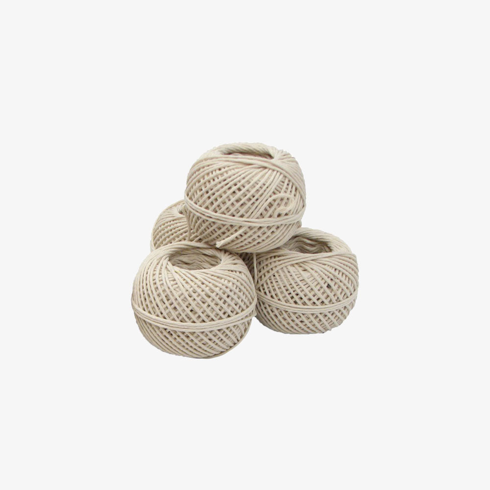 Four cotton string balls stacked together on a white background