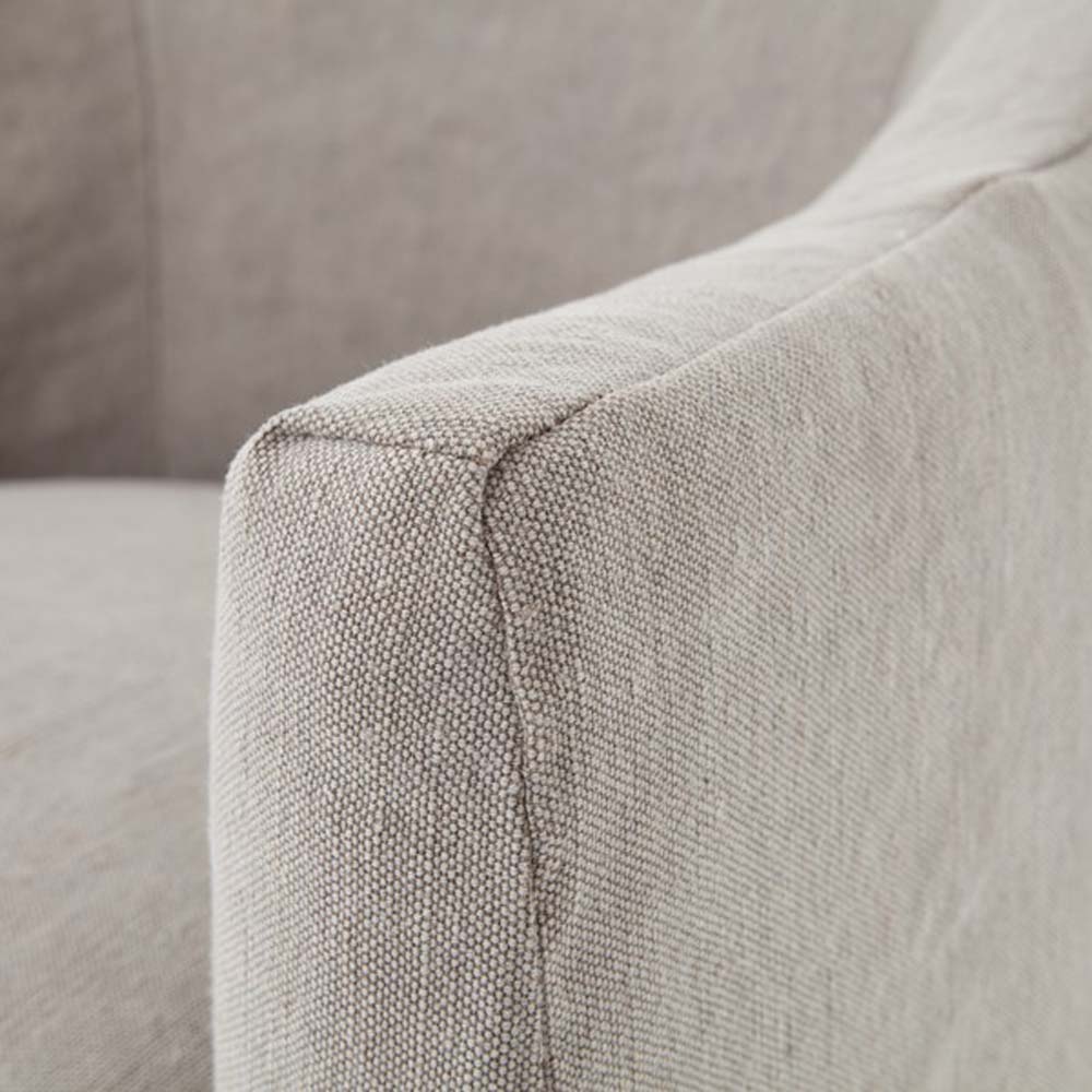 Close up of fabric arm on Four hands furniture brand cove dining chair with linen slip cover