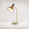 Four hands brand Cullen task lamp in brass with leather shade and walnut accents on a white background