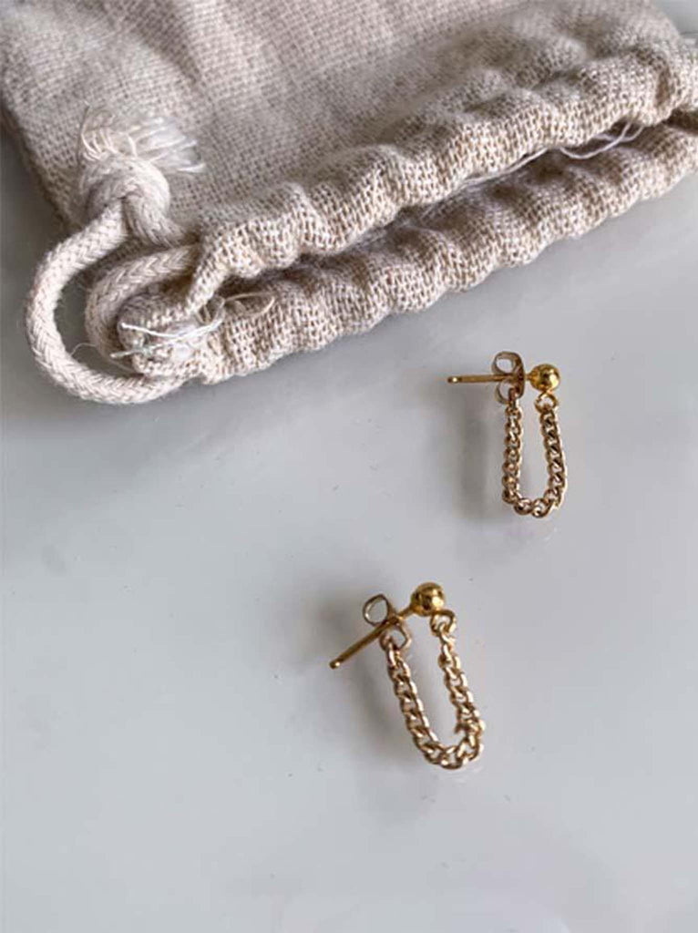Able brand Curb Chain earrings in 14 carat gold fill on a grey background