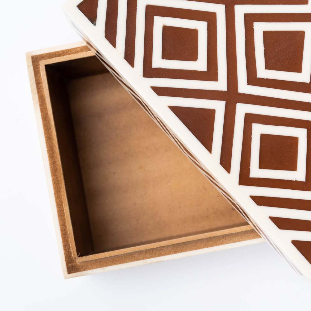 Close up of Brown and white geometric inlay box on a white background