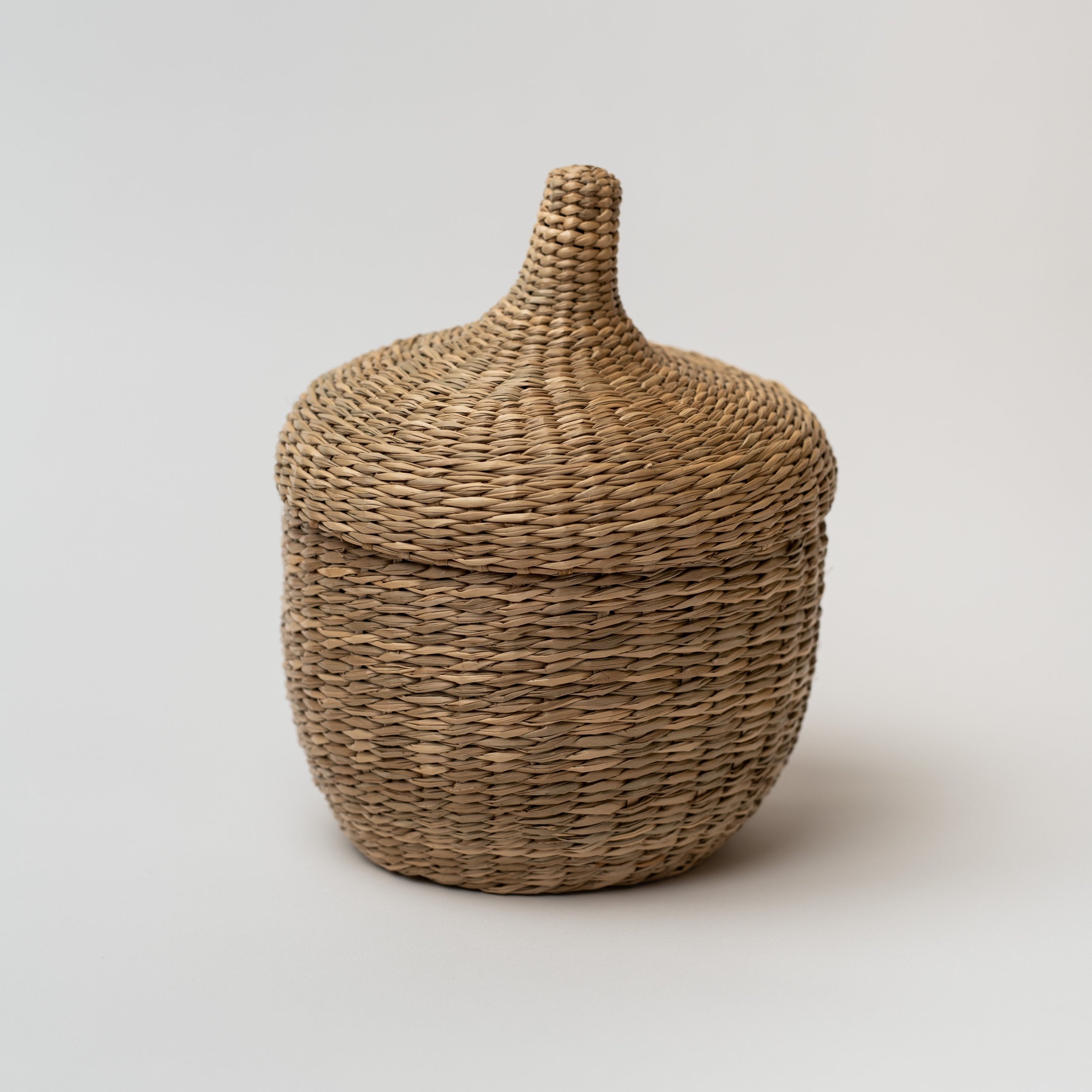 Large seagrass baskets with lid that look like an acorn on a white background