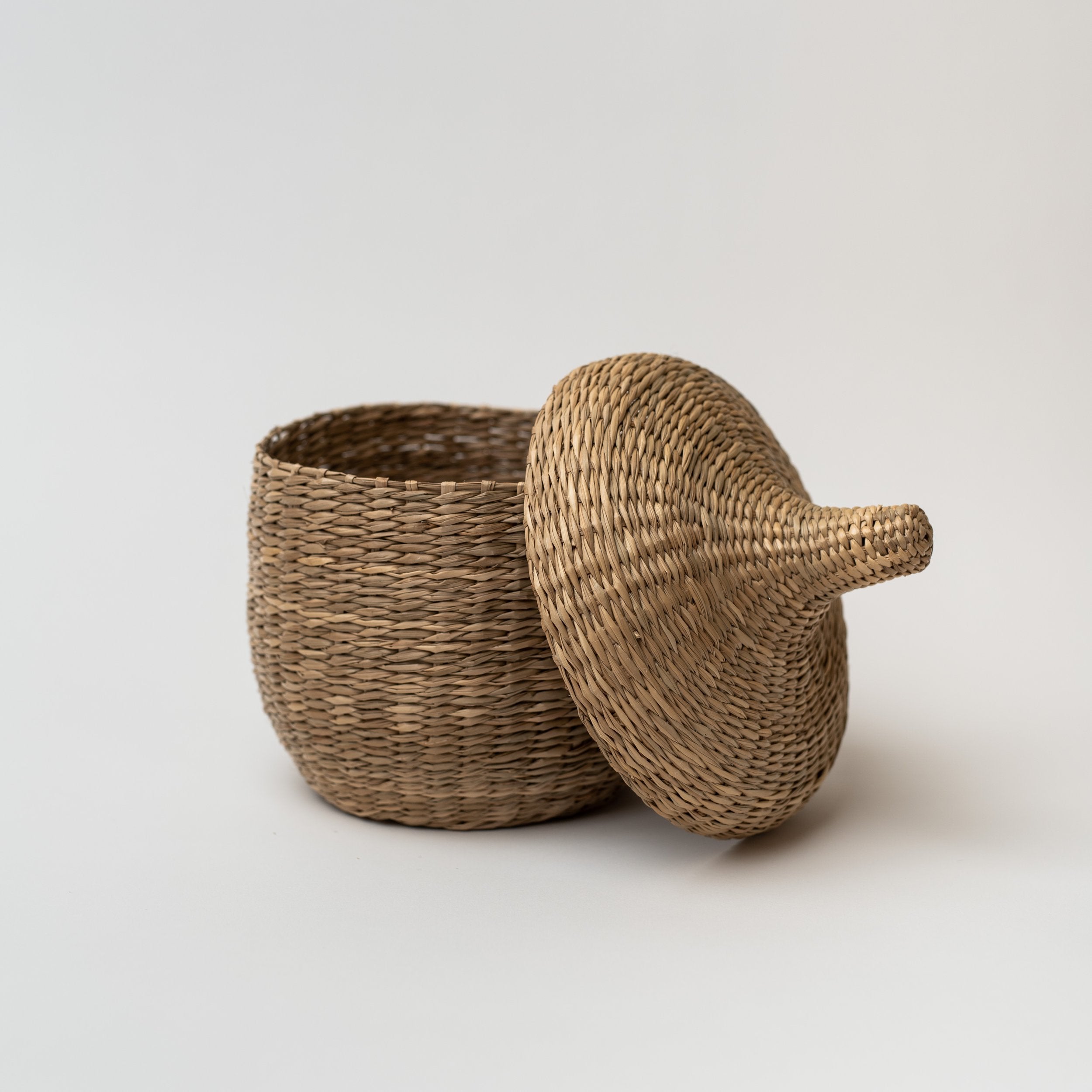 Large seagrass baskets with lid taken off on a white background
