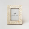 Picture frame with criss cross inlay bone pattern on a white background