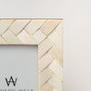 Close up of bone inlay on white picture frame