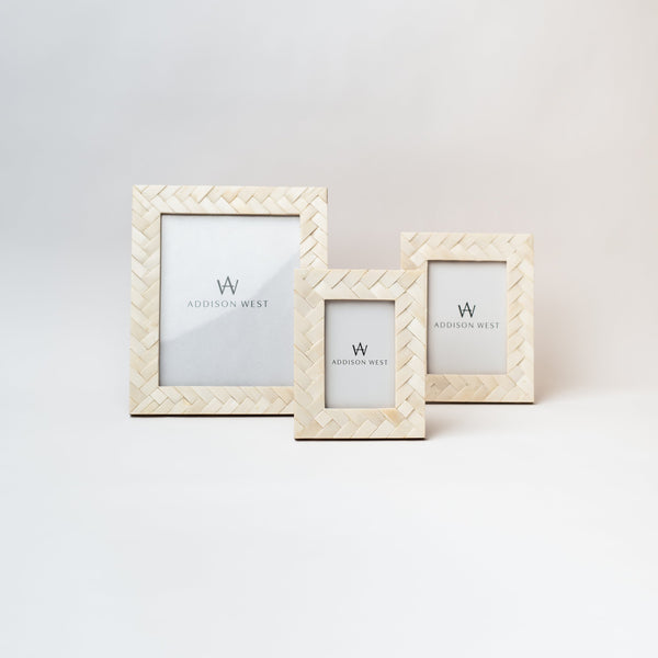 Three picture frames with criss cross inlay bone pattern on a white background