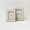 Two white picture frames with brown bone edges on a white background