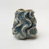 Cream vase with blue flutter pattern on a white background