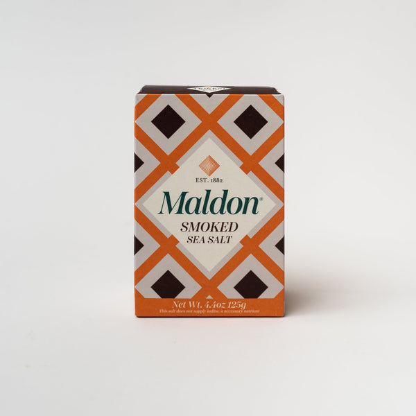 Orange and brown geometric patterned box of Maldon smoked sea salt on a white background
