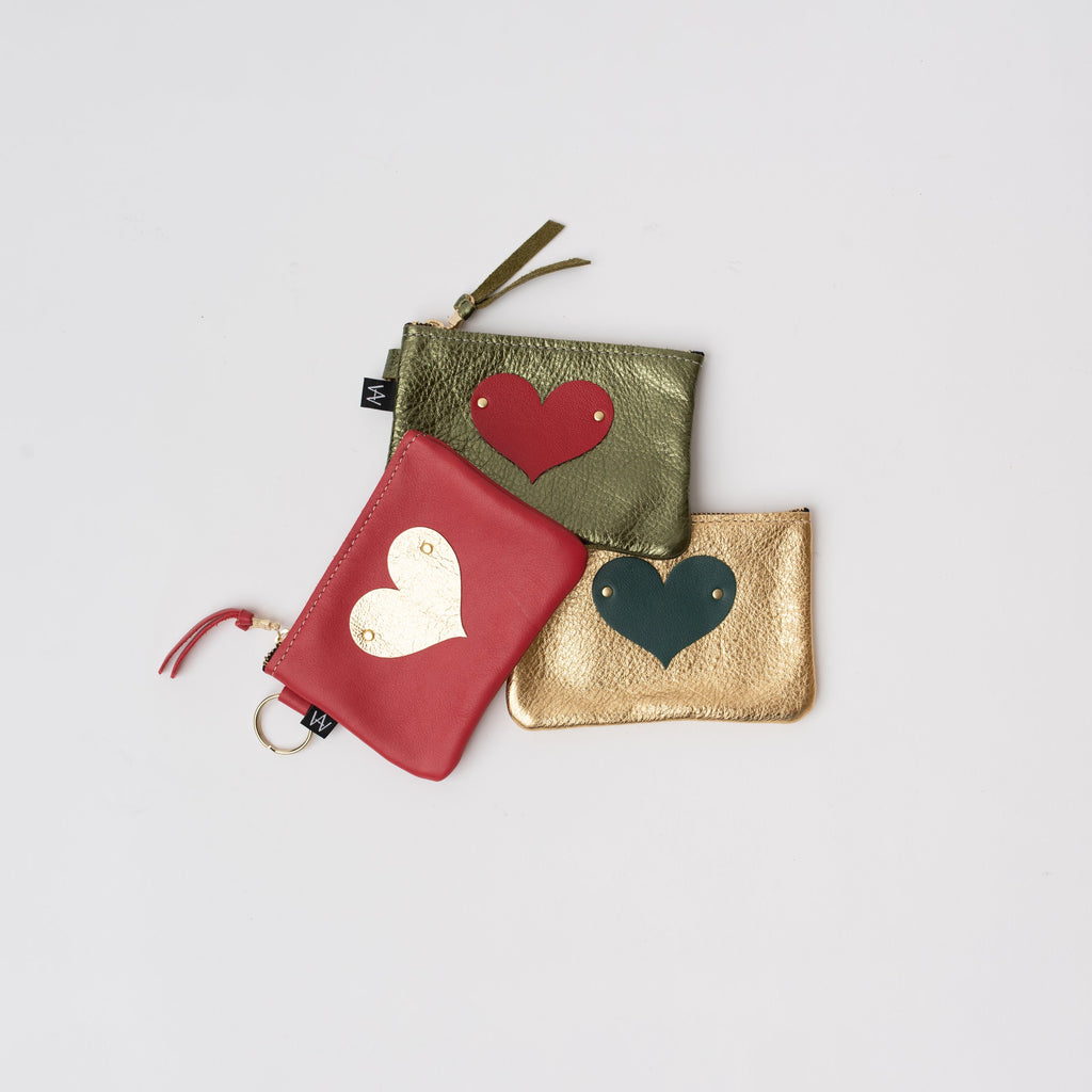 Three small leather pouches with heart appliqué on a white background