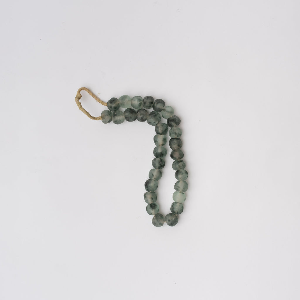 Blue grey colored decorative glass beads on a white background