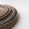 Close up of Nested round sea grass trays on a white background