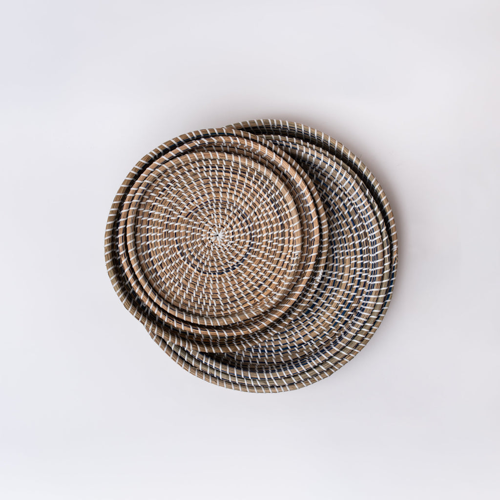Nested round sea grass trays in five sizes on a white background
