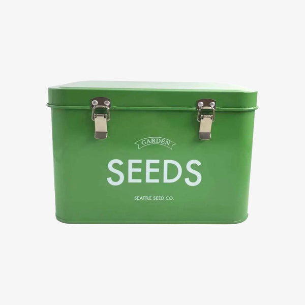 Green metal box with two latches and words 'garden seeds' written in white on a white background