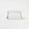 Pressed glass butter dish on a white background