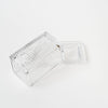Pressed glass butter dish with word 'beurre' on lid on a white background