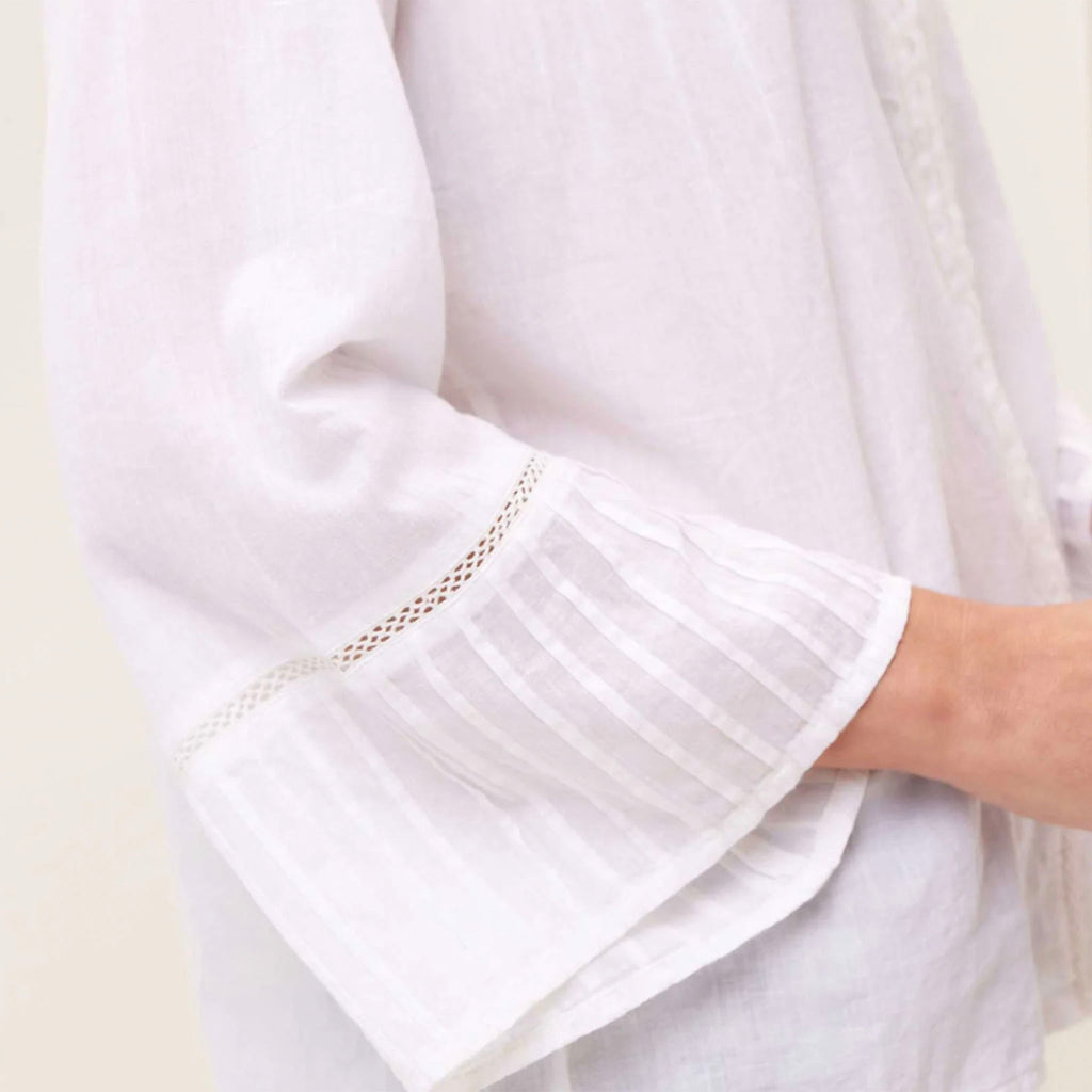 Close up of white light weight cotton top with pin tuck details on model