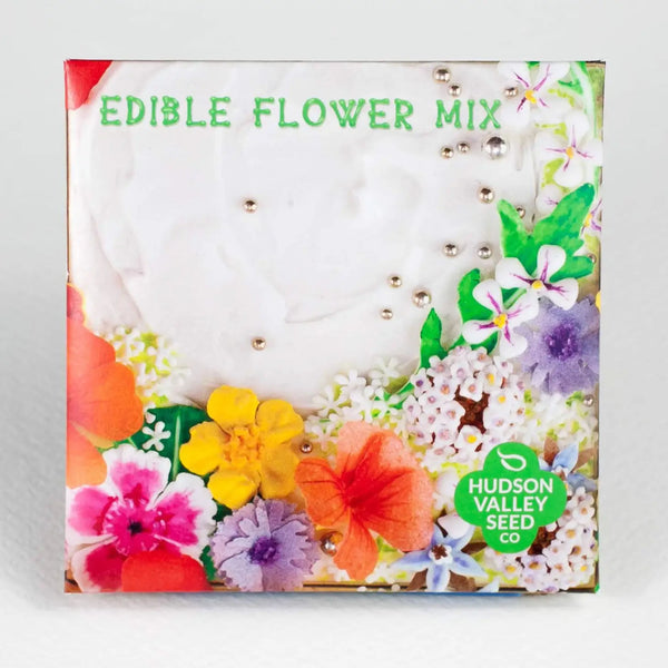 Hudson Valley Seed company edible flower mix seed pack with colorful flowers on a white cake on a grey background