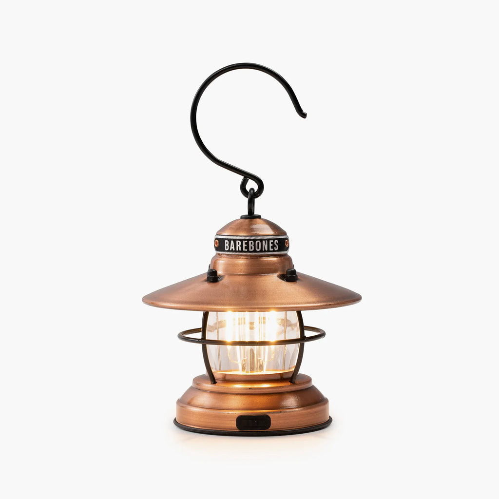 Barebones brand mini Edison lantern with vintage style and caged bulb in copper on a white background